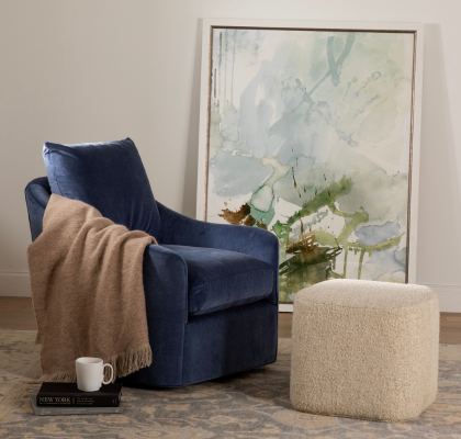 blue swivel chair with throw and a white square ottoman