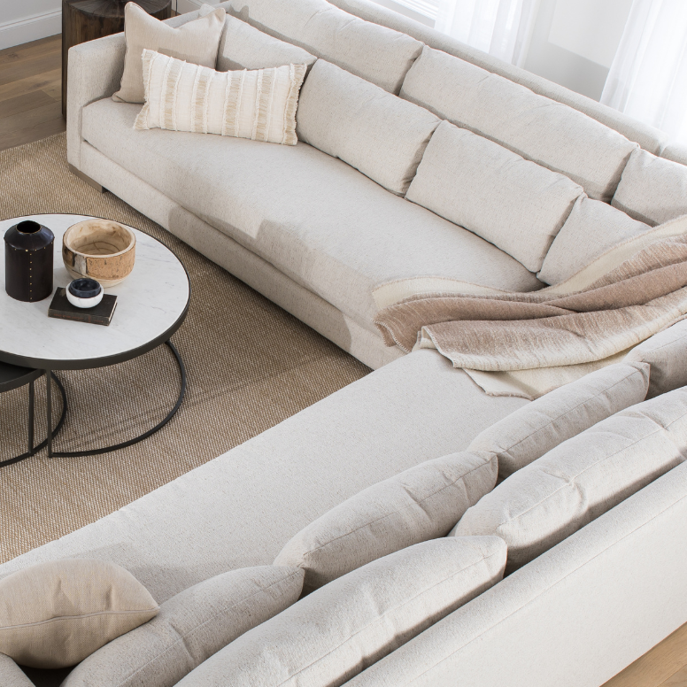 beige sectional with pillows living room setting