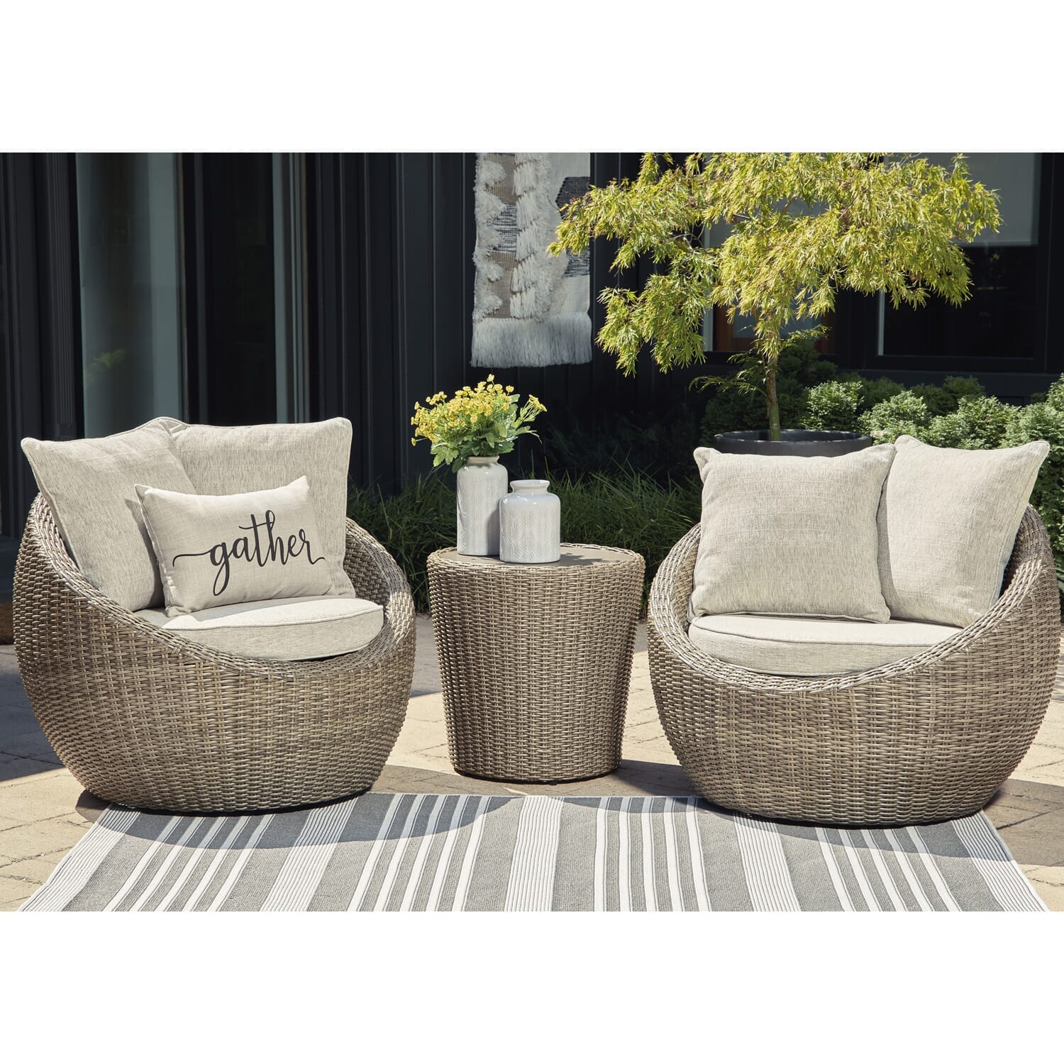 Dawn set of two swivel chairs with resin wicker and upholstered cushions, finished with matching toss pillows and the Dawn End Table with flowers and a vase on top.