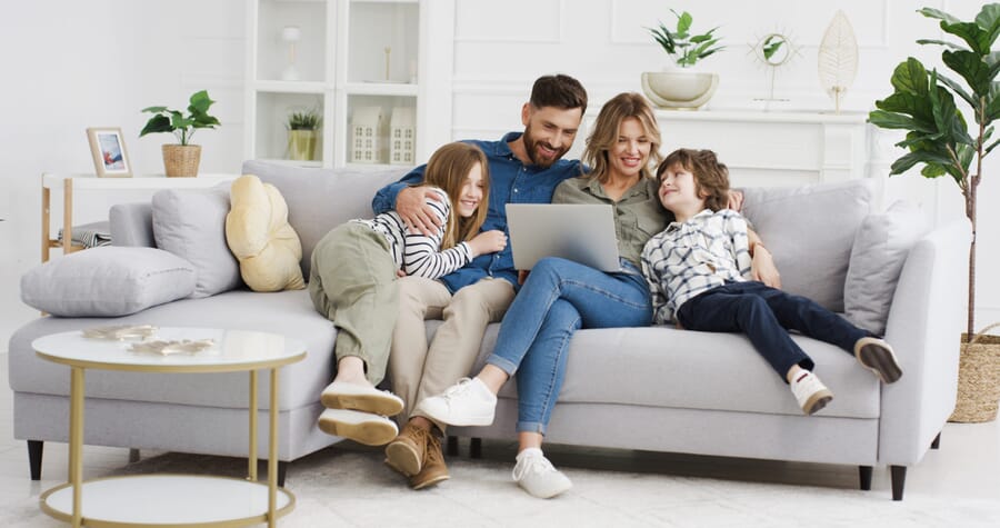 Family of four on gray sectional in living room