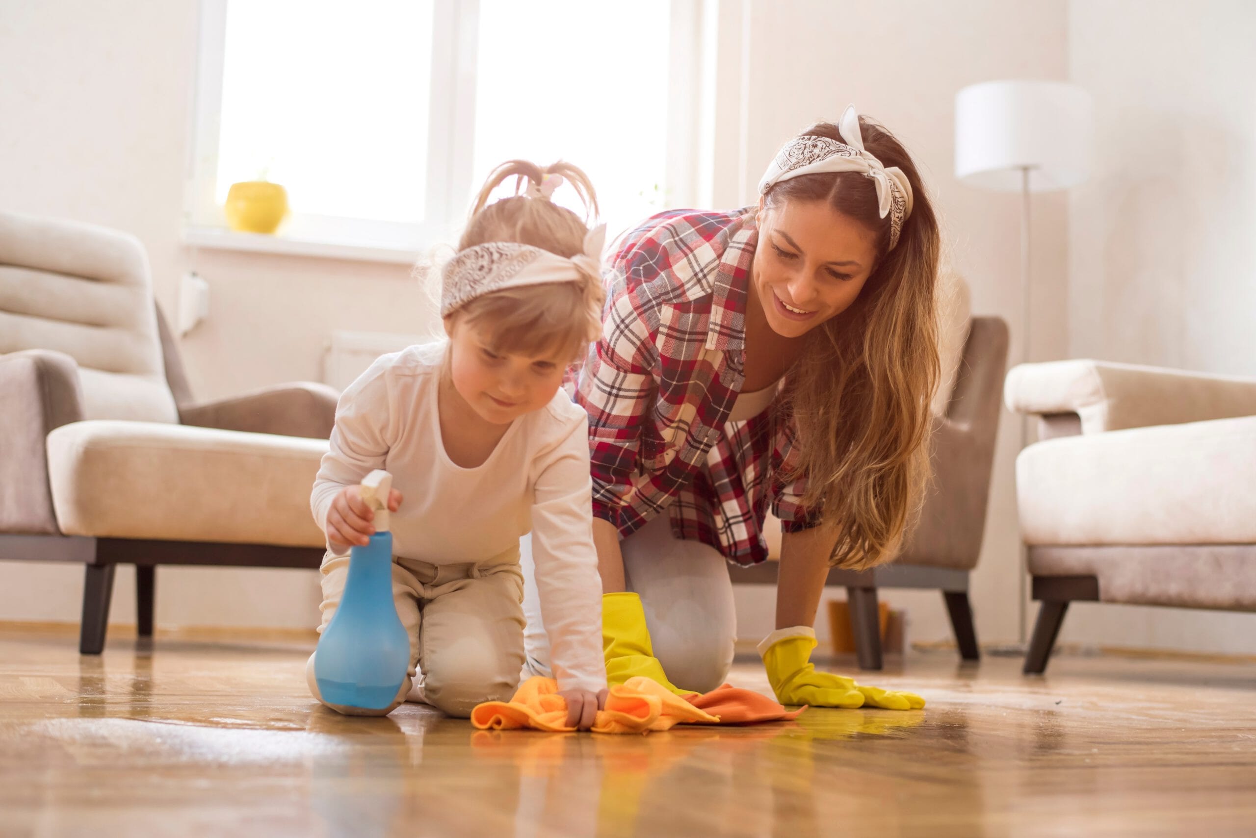 mother and daughter cleaning wood floors and having fun