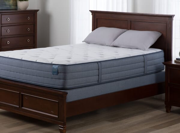 WG&R Factory Direct mattress on a wooden panel bed and two pillows.