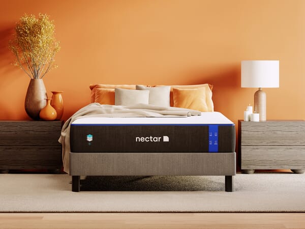 nectar 4.0 bed in a box on bedframe with pillows, a throw and a nightstand on each side.