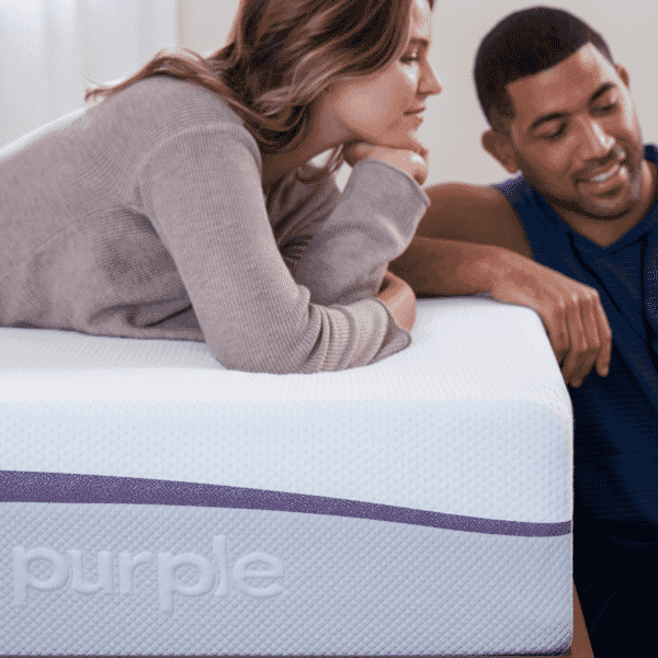 Two people laying and relaxing on a purple mattress
